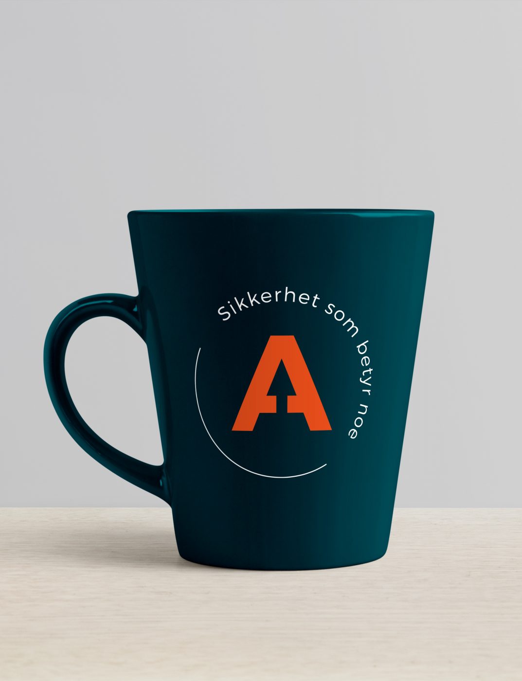 Profilert, blå kaffekopp med oransje Arexa-emblem og påskriften: Vi sikrer det som betyr noe for deg
