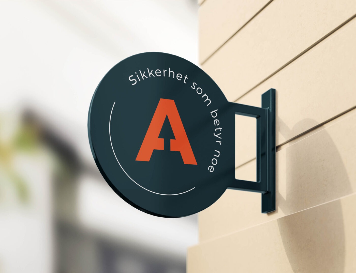 Skilt fastmontert ut fra vegg med Arexa-emblem og teksten: Sikkerhet som betyr noe